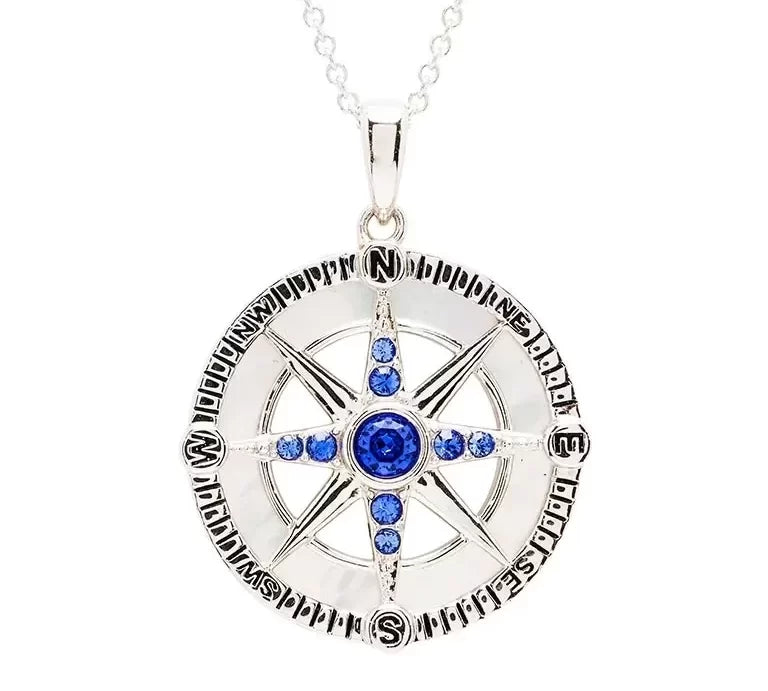 Shanores Swarovski Crystals Mother of Pearl Blue Sapphire Compass Necklace from the Ocean Jewelry collection features a silver compass rose pendant with vibrant gemstones and encircled cardinal directions, making it an elegant accessory for any journey.