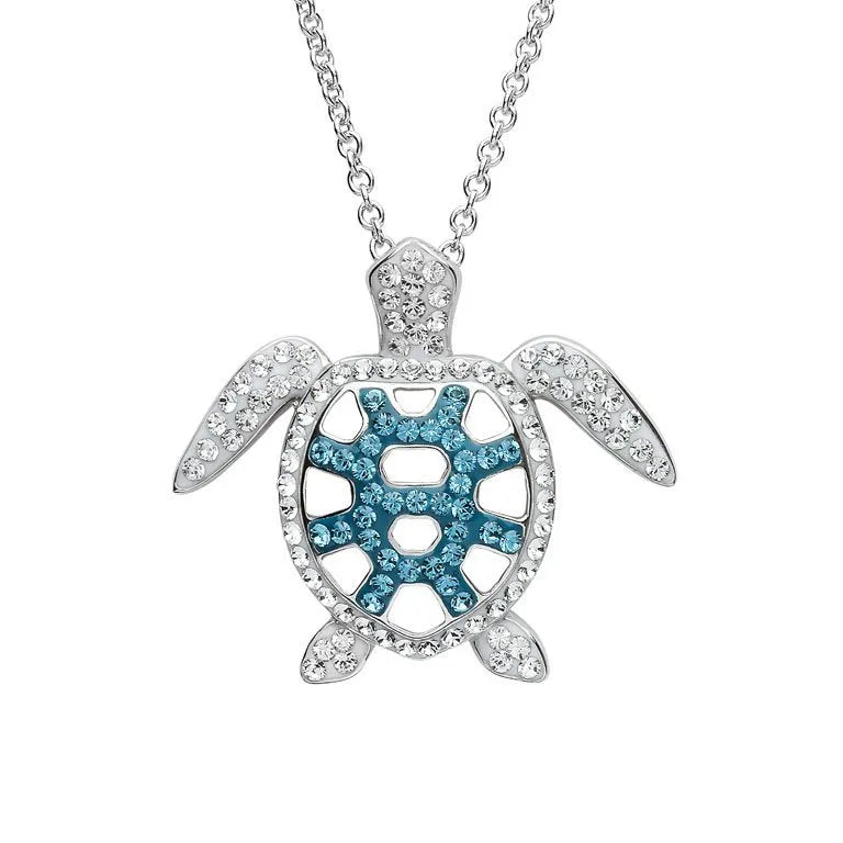 The Shanore Swarovski Crystals Teal Filigree Turtle Necklace features a silver turtle pendant adorned with clear and blue crystals, hanging from a delicate sterling silver chain. The shells blend of stones creates a sparkling effect, making it the perfect Ocean Jewelry piece for any occasion.