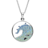 The Shanore Swarovski Crystals Blue Wave Necklace showcases a circular pendant with a stylized ocean wave, embellished with blue and green Swarovski crystals. It is set in polished sterling silver and hangs elegantly from a delicate silver chain.