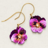 Explore Holly Yashis Sparkling Fuchsia Garden Pansy Drop Earrings featuring vibrant purple pansies with detailed petals and a sparkling center gem. These hypo-allergenic earrings blend artistry and comfort, set against a plain white background.