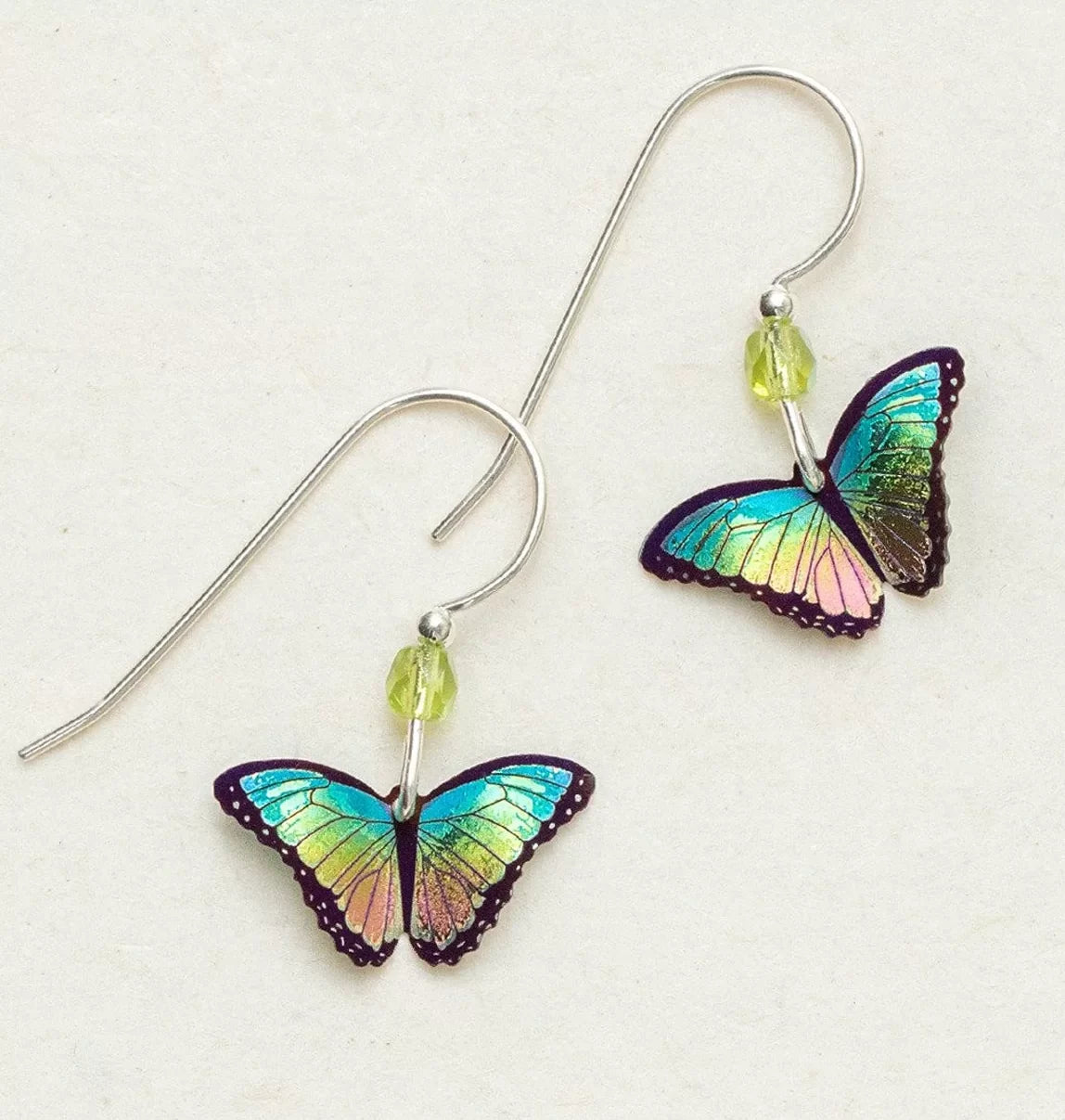 The Island Green Petite Bella Butterfly Earrings by Holly Yashi feature iridescent wings in blue, green, and purple. These handcrafted niobium earrings are lightweight and dangle from simple hooks with a small green bead for a striking appeal.