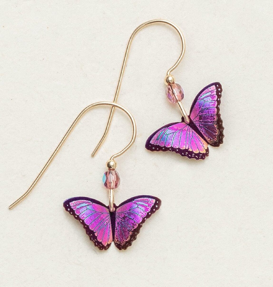 The Ultra Violet Petite Bella Butterfly Earrings by Holly Yashi showcase vibrant butterfly charms in purple, pink, and blue, accented with small pink beads near niobium hooks. These earrings are stylish on a light background and hypo-allergenic for sensitive ears.