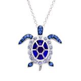 The Shanore Swarovski Crystals September Birthstone Turtle Necklace from Ocean Jewelry features a sterling silver turtle adorned with blue sapphires and clear gemstones on its hexagonal shell, flippers, and head, making it perfect for September birthdays.