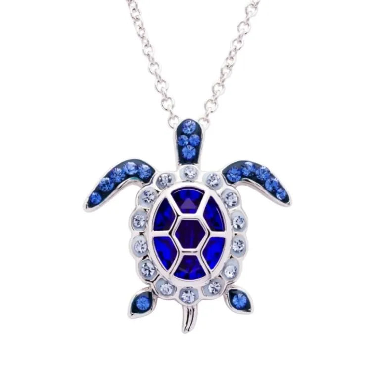 The Shanore Swarovski Crystals September Birthstone Turtle Necklace from Ocean Jewelry features a sterling silver turtle adorned with blue sapphires and clear gemstones on its hexagonal shell, flippers, and head, making it perfect for September birthdays.