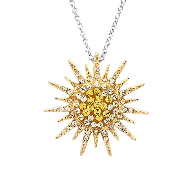 The Shanore Sterling Silver Sunburst Necklace from Ocean Jewelry features a pendant adorned with yellow and clear Swarovski crystals. The radiant sun, with pointed rays, elegantly hangs from the chain, making it a stunning piece.