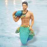 The Turtle Time Ornament by December Diamonds features a striking merman with a muscular upper body holding a turtle. His glittery turquoise and green tail is complemented by a seashell necklace and belt, set against rippling water, making it perfect for nautical-themed decor.