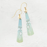 The Sage Tula Earrings by Holly Yashi feature hypo-allergenic, niobium-crafted triangular pieces with a blue-to-green gradient and floral designs, finished with gold hooks and set on a textured white background.