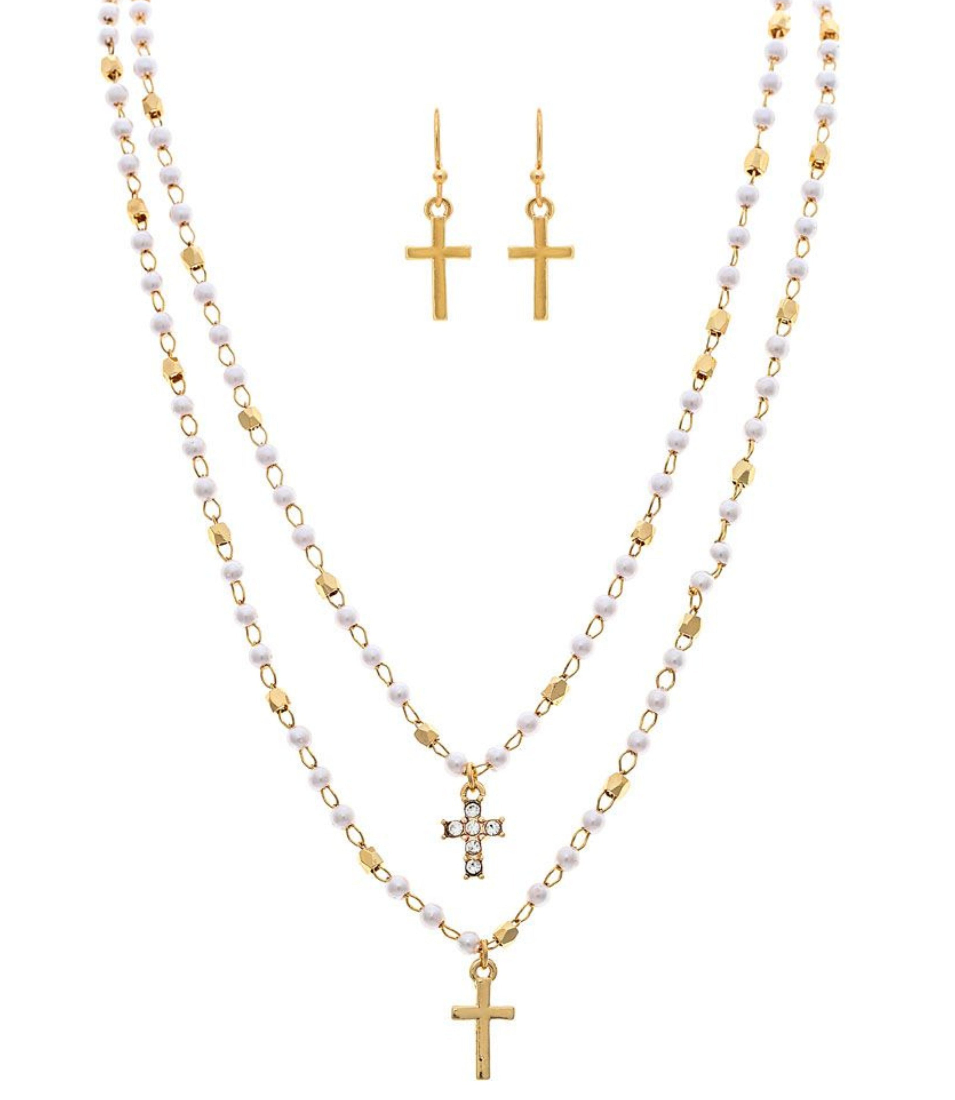 The A-Train Gold Faux Pearl Cross Charm Layered Necklace Set includes two cross pendants and matching gold cross earrings, all displayed on a white background.