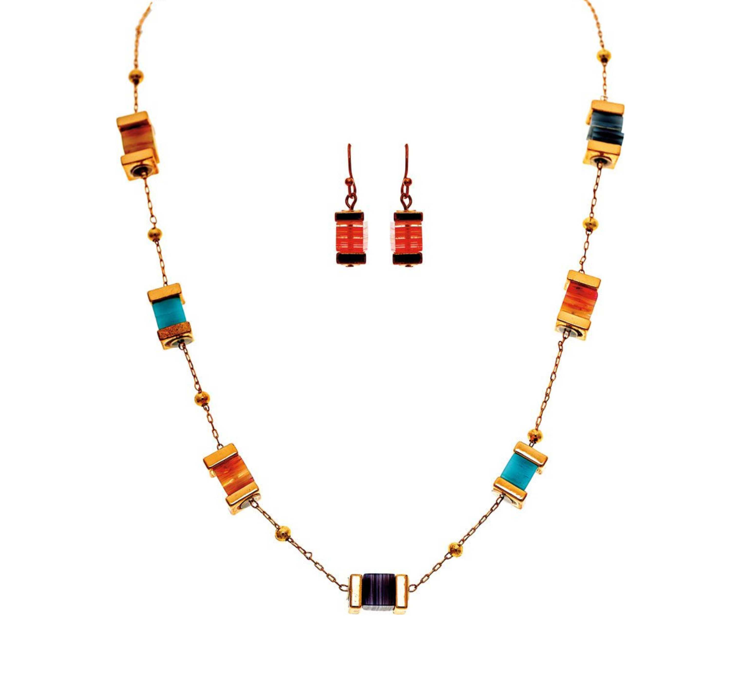 The A-Train Gold Color Bead Stack Station Necklace Set features a gold-tone necklace with rectangular orange, turquoise, and purple beads plus matching orange dangle earrings, all displayed on a white background.