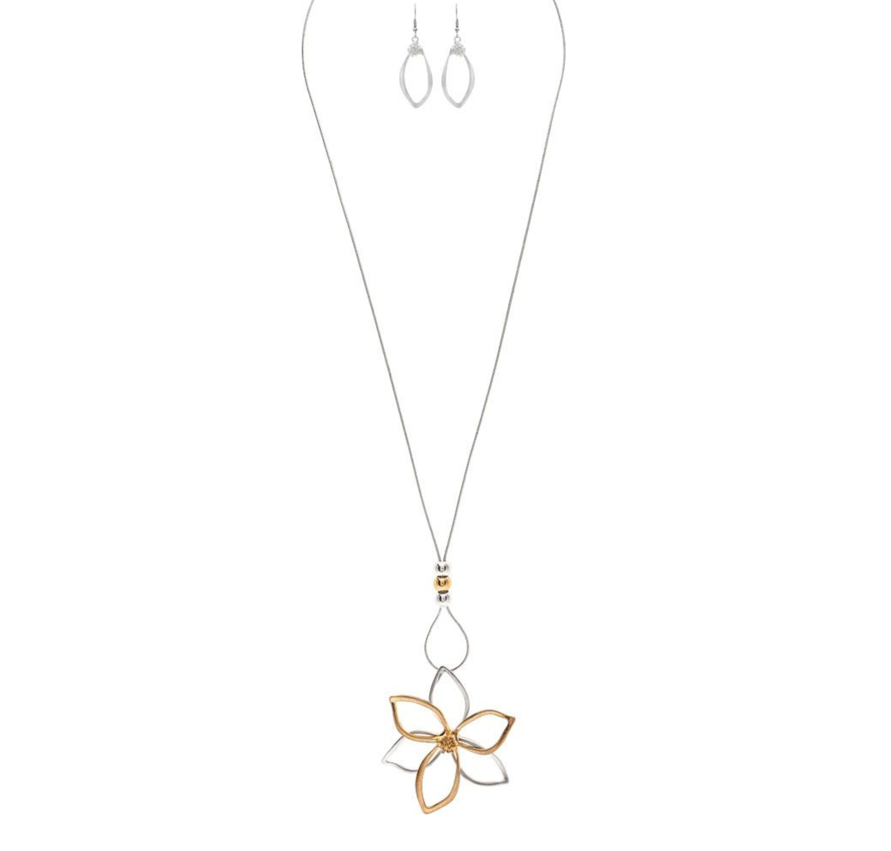 The A-Train Two-Toned Big Flower Long Necklace Set includes a long silver chain with an openwork flower pendant in gold and silver tones, crafted from mixed jeweler’s metals, and comes with matching drop earrings.