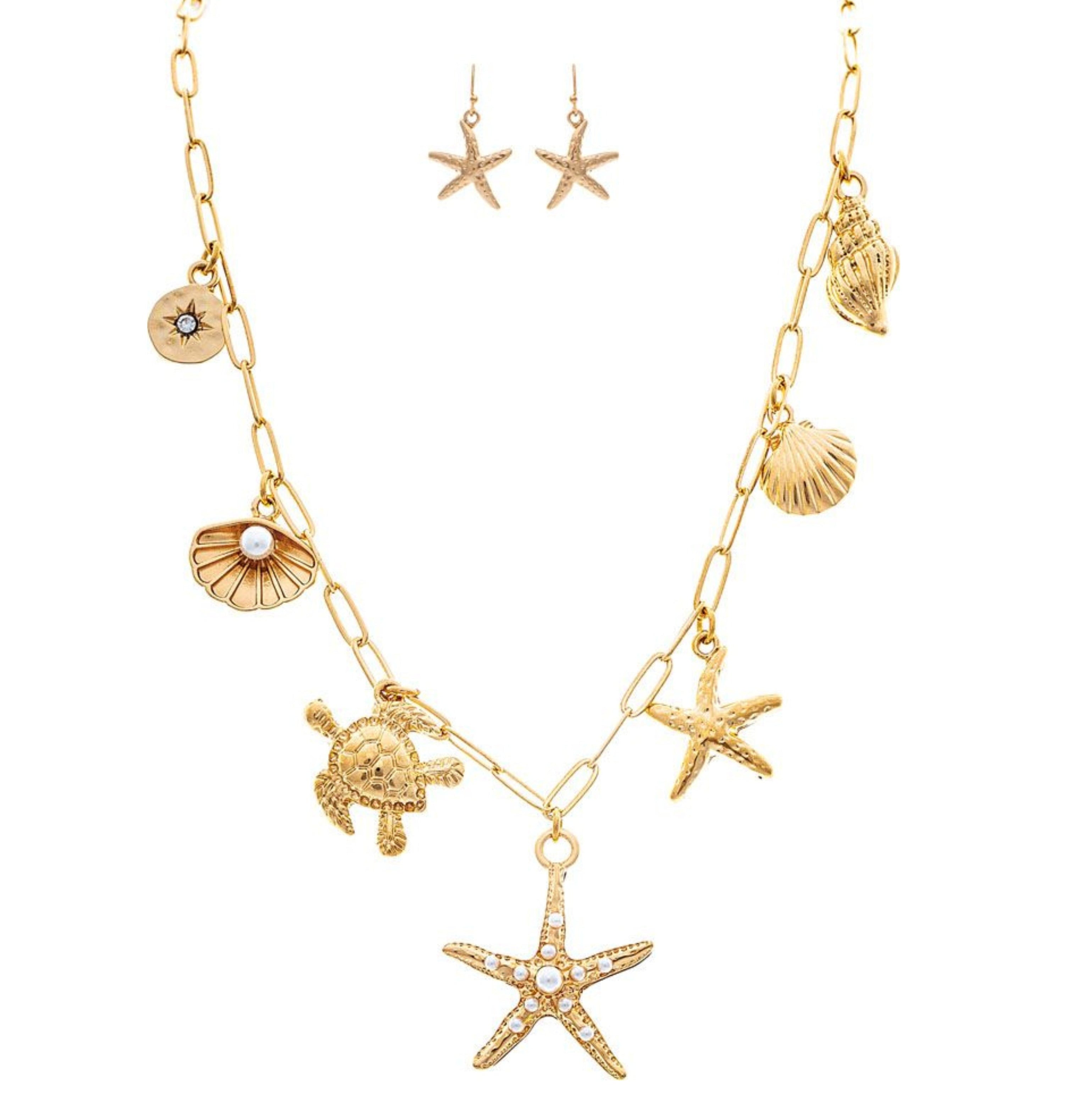 The A-Train Gold Chain Charming Sealife Necklace Set features a gold chain with starfish, seashells, turtle, and crystal accents, plus matching gold starfish drop earrings.