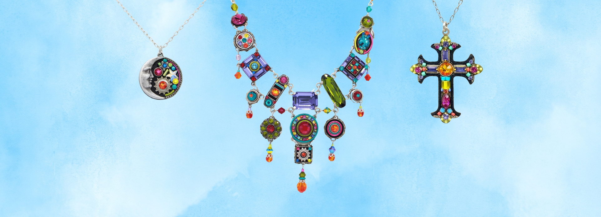 Four colorful necklaces on silver chains are displayed against a soft blue background, featuring floral, dragonfly, drop, and oval gemstone designs with vibrant orange, red, and multicolored stones.