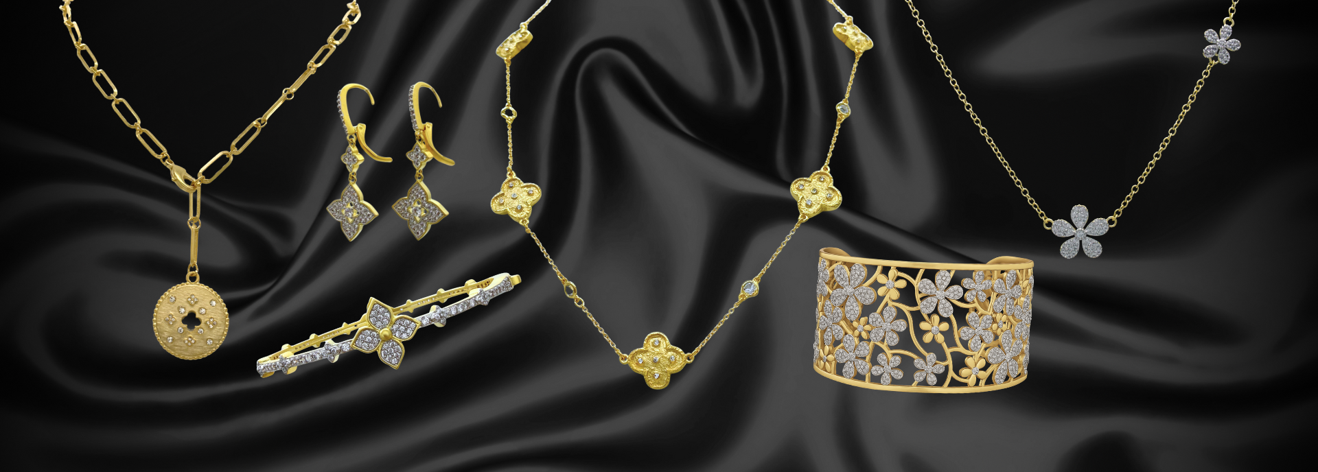 Various elegant gold and diamond jewelry pieces, including necklaces, earrings, bracelets, and a wide cuff, are displayed on a smooth black silk background.