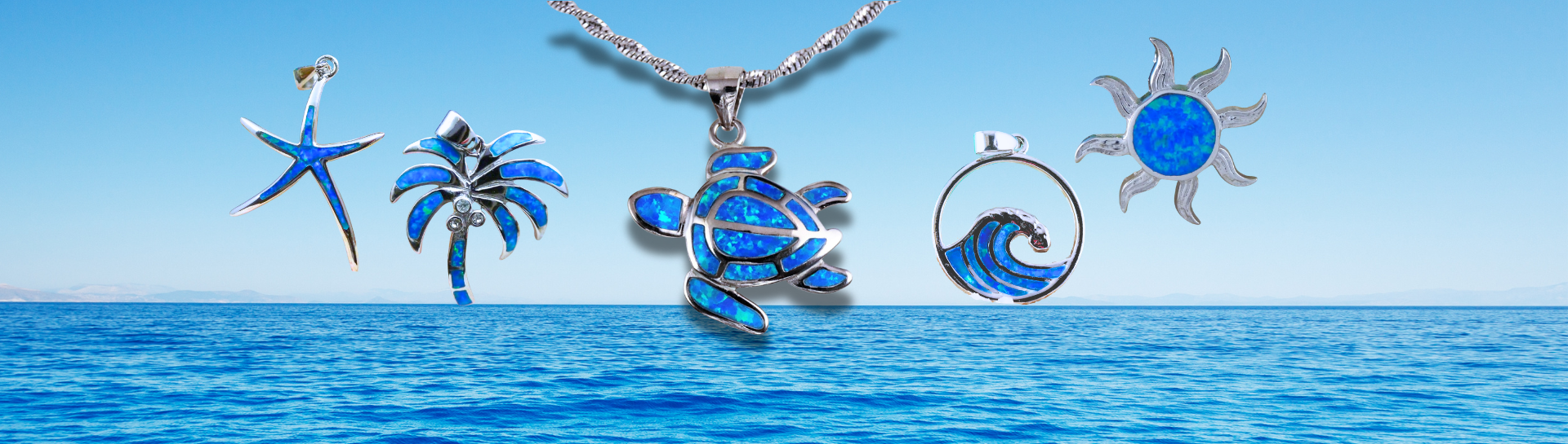 Five silver necklaces with ocean-themed pendants—teardrop, turtle, sun, palm tree, and oval—displayed against a tropical beach with turquoise water and blue sky.