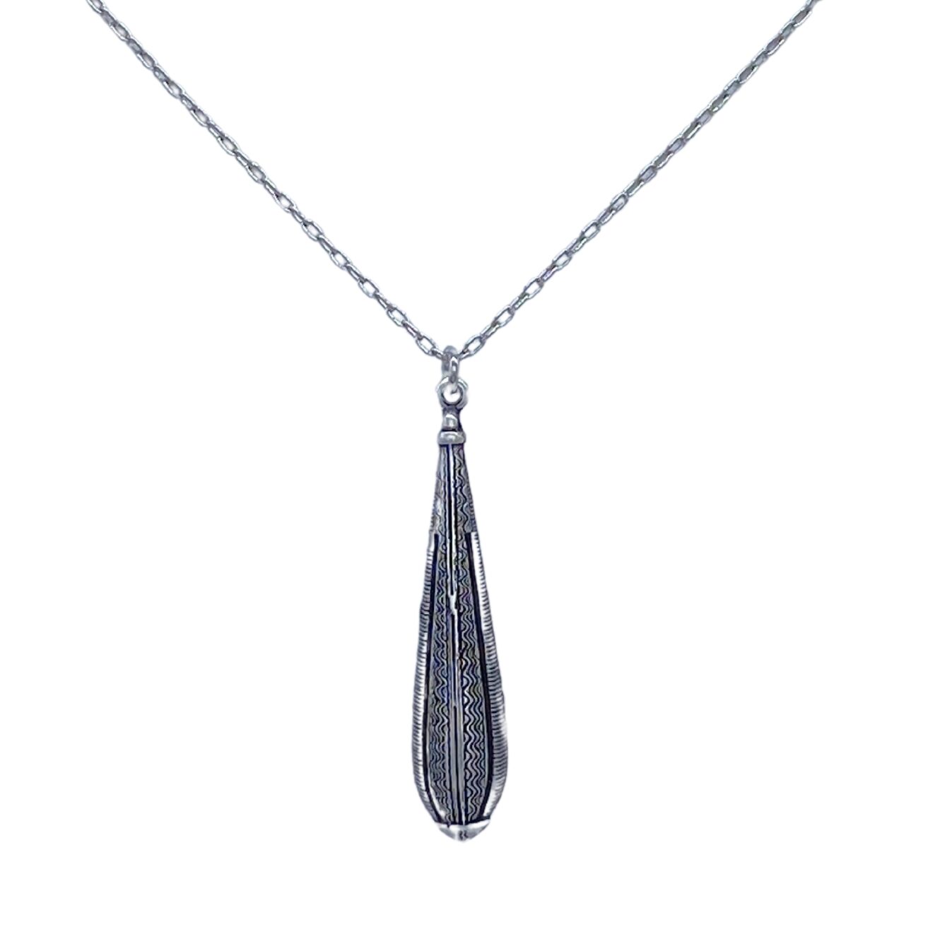 This fair-trade Firefly jewelry piece, the Large Gazelle Red Drop Necklace, features a silver necklace with a feather-shaped pendant. Meticulously handmade in Guatemala, its intricate engravings add texture while the delicate chain enhances its elegance.