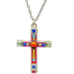 The Large Cross Multi-Color Necklace by Firefly features a handmade silver cross adorned with vibrant red, blue, green, and yellow gems—the central gem is a striking red—all on a silver chain. Crafted in Guatemala.