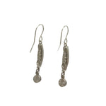 These exquisite Linear Two Tier Multi-Color Earrings by Firefly, handmade in Guatemala, showcase an intricate cylindrical design with decorative patterns and a small charm. Crafted with care against a plain white backdrop, they embody fair-trade practices.