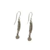 These exquisite Linear Two Tier Multi-Color Earrings by Firefly, handmade in Guatemala, showcase an intricate cylindrical design with decorative patterns and a small charm. Crafted with care against a plain white backdrop, they embody fair-trade practices.