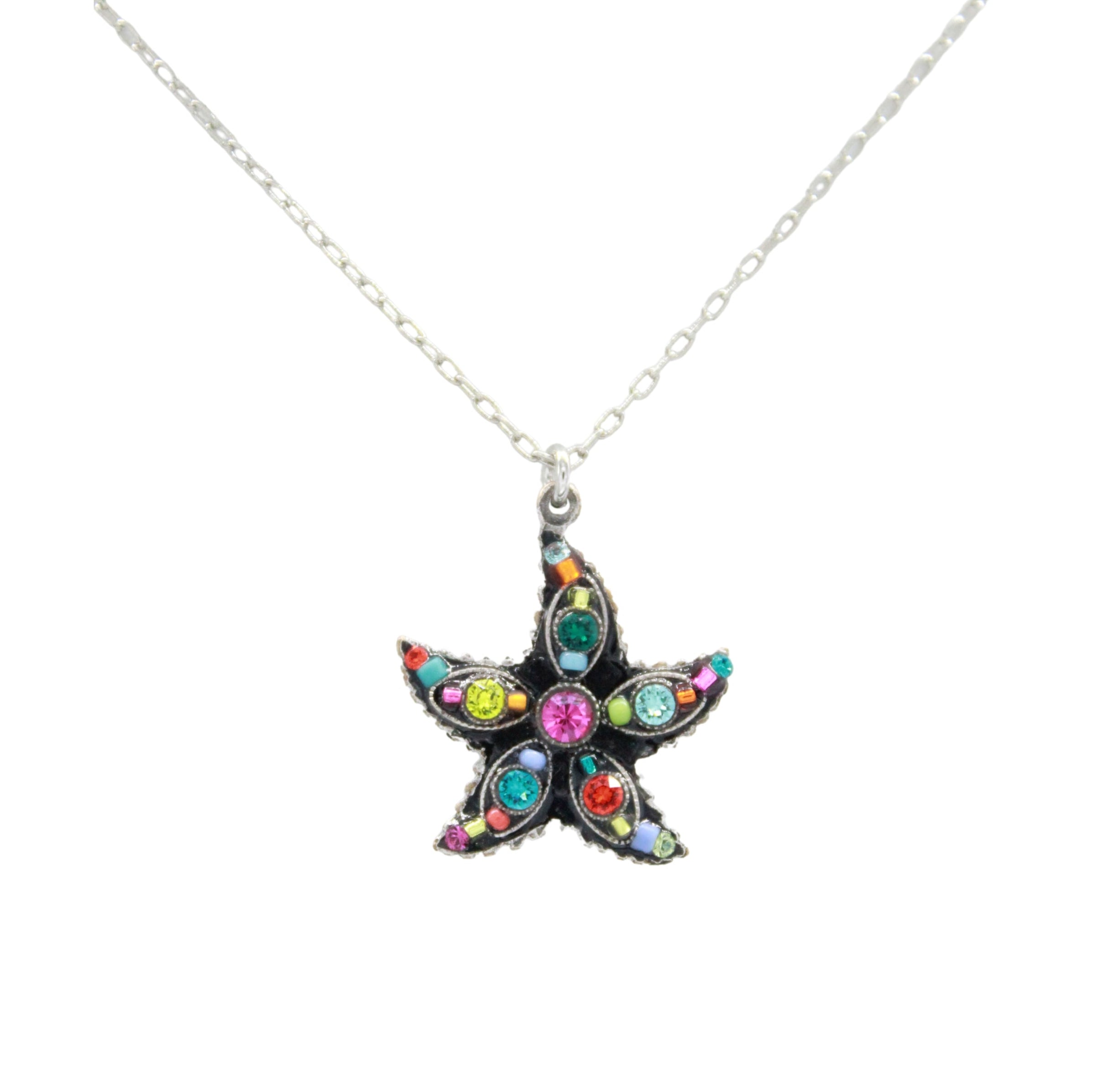 The Firefly Starfish Multi-Color Necklace features a handmade starfish pendant with vibrant pink, blue, green, yellow, and red gemstones on a silver chain. Crafted in Guatemala by Firefly Jewelry.