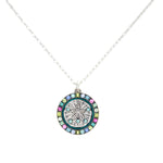 The Playa Sand Dollar Soft Necklace by Firefly features a silver round sand dollar pendant accented with blue, green, and pink gemstones. This handmade Firefly Jewelry piece adds the perfect touch to any ensemble.