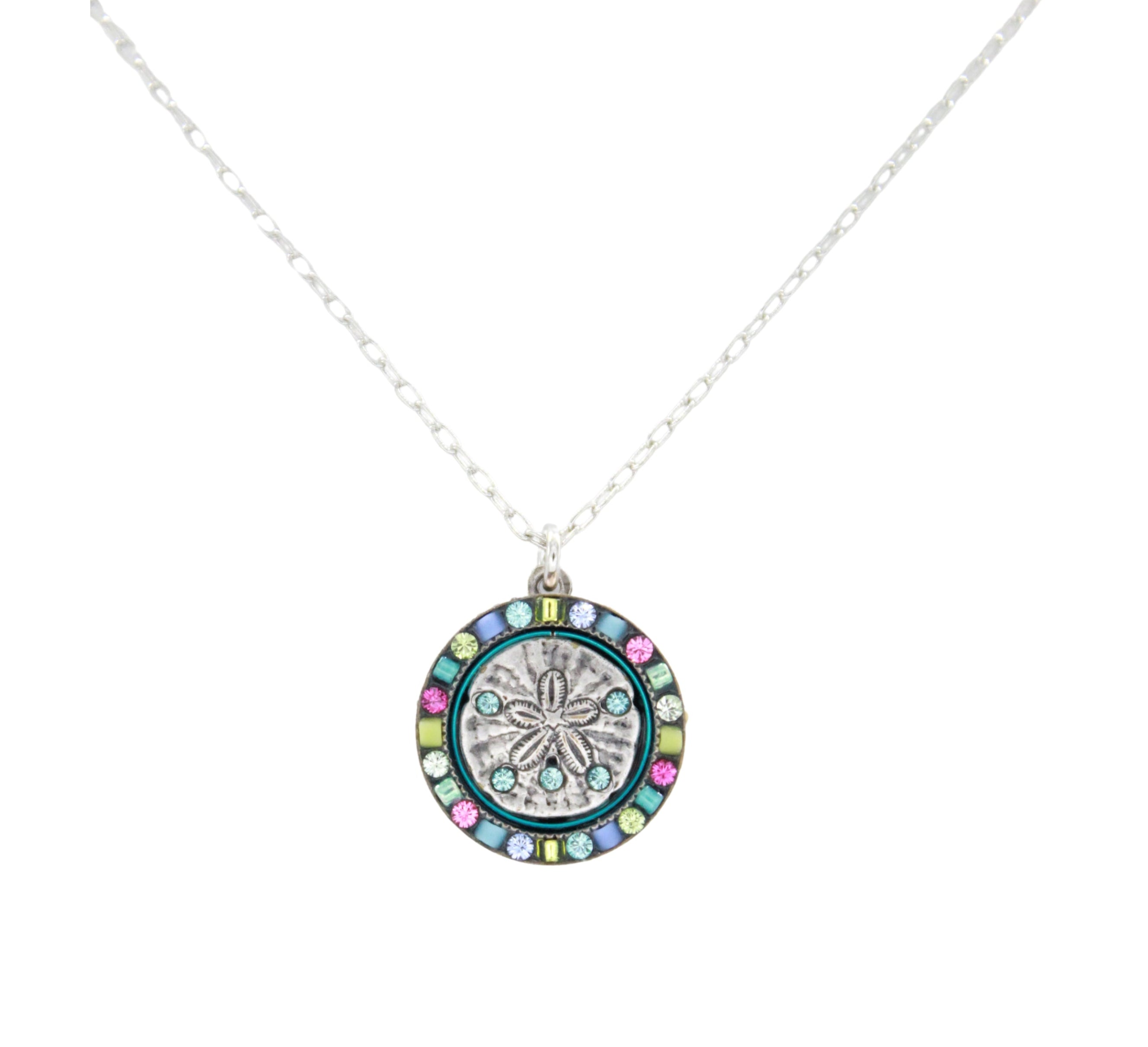 The Playa Sand Dollar Soft Necklace by Firefly features a silver round sand dollar pendant accented with blue, green, and pink gemstones. This handmade Firefly Jewelry piece adds the perfect touch to any ensemble.