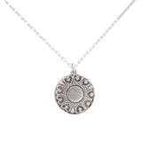 The Playa Sand Dollar Soft Necklace by Firefly features a hypo-allergenic silver round pendant with heart-shaped accents and a central circle, inspired by beach sand dollars, displayed against a white background.