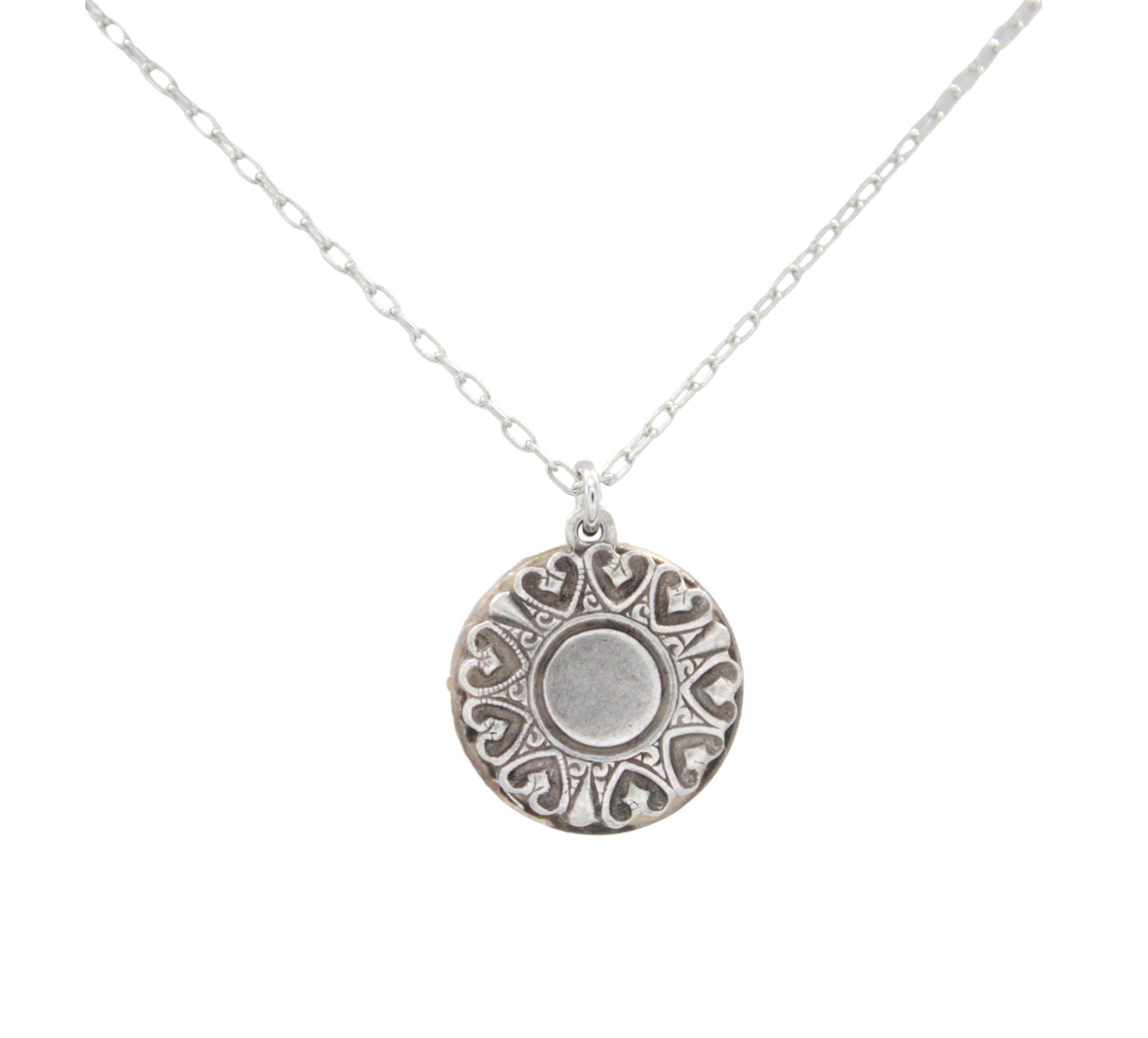 The Playa Sand Dollar Soft Necklace by Firefly features a hypo-allergenic silver round pendant with heart-shaped accents and a central circle, inspired by beach sand dollars, displayed against a white background.