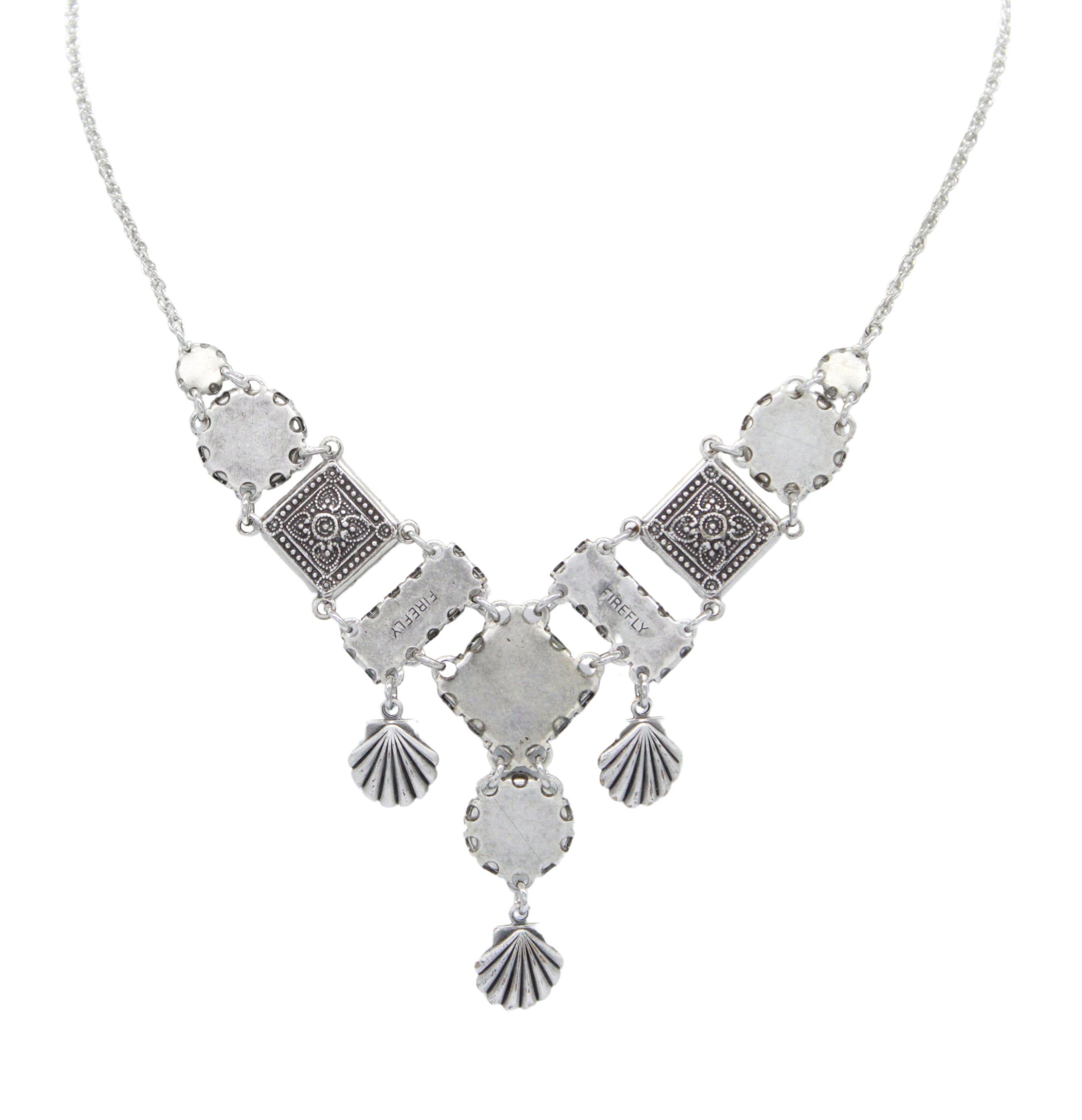 The Firefly Ocean Elaborate Soft Necklace features an ornate pendant with geometric and filigree designs, plus three shell-shaped charms—handmade in Guatemala.