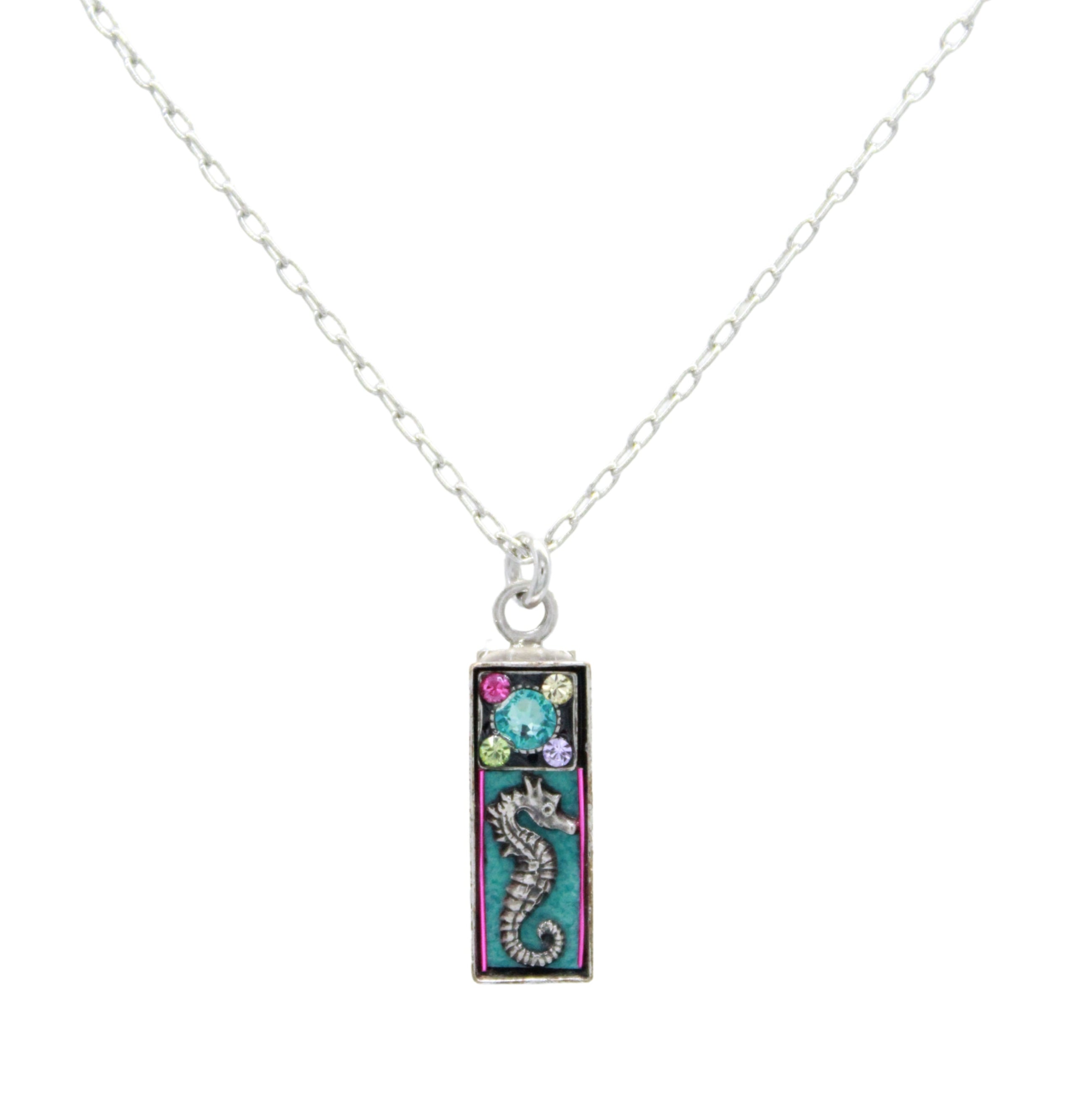 The Mini Seahorse Soft Necklace by Firefly features a delicate silver chain with a rectangular turquoise pendant adorned with a seahorse and colorful floral accents. Handmade in Guatemala by Firefly Jewelry.