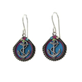 The Playa Anchor Soft Earrings by Firefly feature silver, shell-shaped blue pendants with a central anchor design and colorful accents. Handmade in Guatemala, theyre a stunning fair-trade jewelry piece.