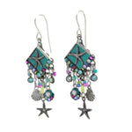 The Playa Starfish Fringe Soft Earrings by Firefly feature teal diamond-shaped tops, starfish motifs, multicolored beads, and silver-tone shell and starfish charms—handmade in Guatemala.