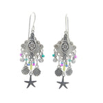 The Playa Starfish Fringe Soft Earrings by Firefly feature intricate silver dangles with colored beads, shell-shaped charms, and starfish pendants. Handmade in Guatemala, these hypo-allergenic earrings blend unique style and artisan craftsmanship.