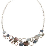 The Oxidized Silver/Blue & Black Lip Shell Necklace Set features an asymmetrical cluster of circular charms made of textured oxidized silver and iridescent lip shells.