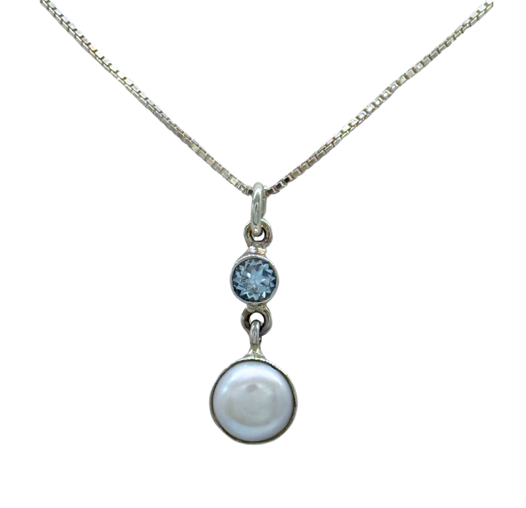 The Freshwater Pearl Round Blue Topaz Necklace by Mediterranean Artists Co. features a small round blue topaz above a larger white freshwater pearl, both set in 925 sterling silver.