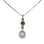 The Freshwater Pearl Round Blue Topaz Necklace by Mediterranean Artists Co. Sterling Silver features a thin 925 silver chain with double pendants: a small round freshwater pearl and a larger marbled blue topaz stone.