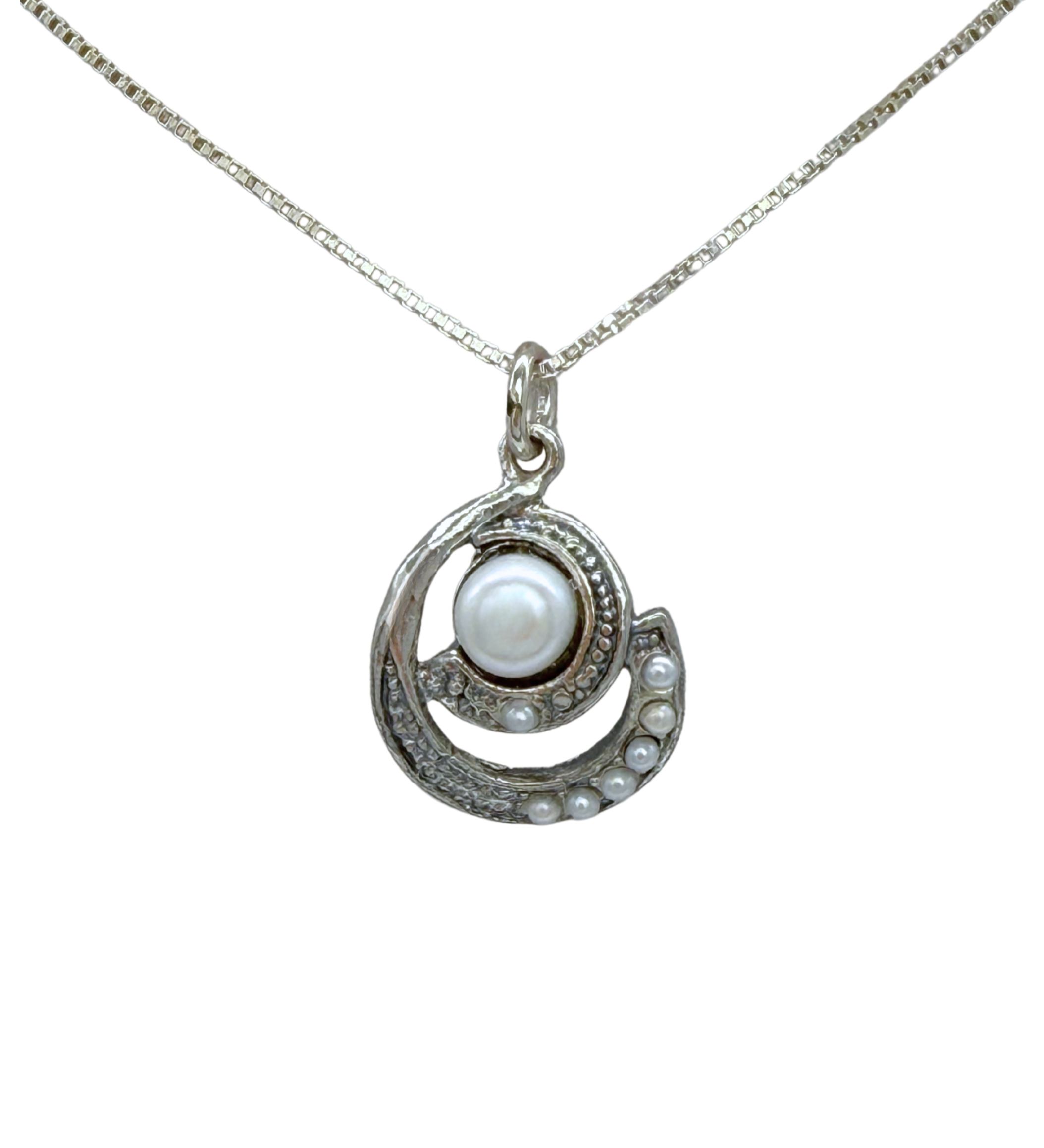 The Mediterranean Artists Co. Sterling Silver Spiral Freshwater Pearl Center Necklace features a circular sterling silver pendant with a large central freshwater pearl and smaller pearls set in a crescent design.