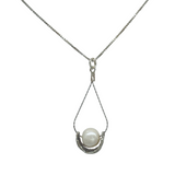 The Sterling Silver Wire Basket Freshwater Necklace by Mediterranean Artists Co. Sterling Silver features a white freshwater pearl in a teardrop wire setting—a perfect choice for freshwater pearl necklace enthusiasts.