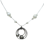 The Sterling Silver Circles Freshwater Pearl Station Chai Necklace by Mediterranean Artists Co. Sterling Silver features a circular pendant with three interlocking rings, two small spheres, and a chain accented by irregular white freshwater pearls.
