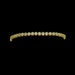 The Be-Je Designs Gold & Clear CZ Tennis Bracelet showcases round clear cubic zirconia set in 14kt gold with a sleek black backdrop—a versatile, luxurious accessory for any occasion.