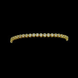 The Be-Je Designs Gold & Clear CZ Tennis Bracelet showcases round clear cubic zirconia set in 14kt gold with a sleek black backdrop—a versatile, luxurious accessory for any occasion.