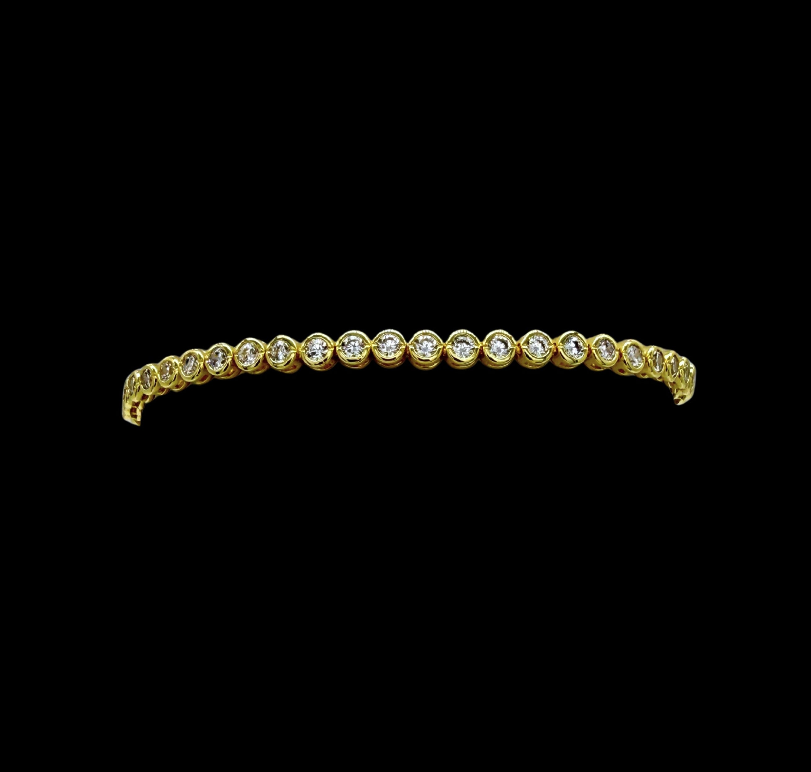 The Be-Je Designs Gold & Clear CZ Tennis Bracelet showcases round clear cubic zirconia set in 14kt gold with a sleek black backdrop—a versatile, luxurious accessory for any occasion.