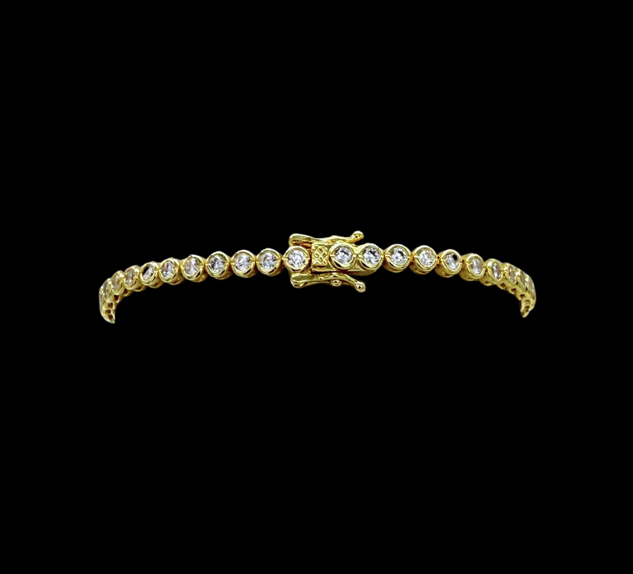 The Be-Je Designs Gold & Clear CZ Tennis Bracelet features a single row of sparkling round cubic zirconia set in 14kt gold, beautifully displayed on a black background.