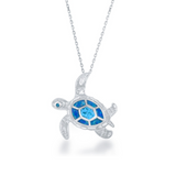 The Classic of New York Caribbean Opal Inlay Turtle Necklace features a sterling silver sea turtle pendant with a blue and turquoise mosaic shell and rhodium plating, elegantly suspended from a delicate chain.