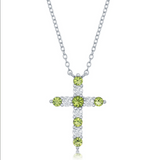 The Classic of New York Sterling Silver Birthstone Cross (August) Necklace features alternating round peridot and clear stones in a cross pendant, shown against a white background.