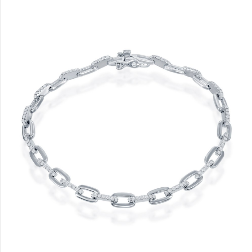 The Classic of New York Sterling Silver & CZ Paperclip Bracelet, featuring elongated oval links and sparkling stones, is showcased against a white background.