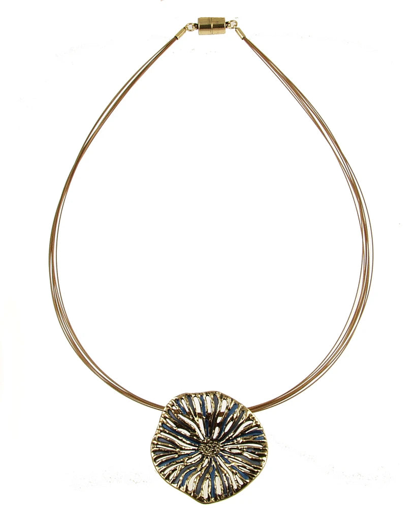 The Origin Textured Round Organic Pendant Gold/Blue Necklace is a gold-tone wire choker featuring an organic, textured round pendant with dark blue accents and a magnetic closure.