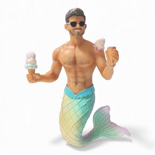 The Creamtastrophe Ornament by December Diamonds features a hand-painted merman with a muscular torso, sunglasses, and a pastel tail, holding an ice cream and drink—a playful update to classic mermaid ornaments.