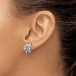 A close-up of a persons ear wearing Presco/Quality Golds Swarovski Crystals Light Blue Turtle Post Earrings, featuring a turtle design with a light blue crystal shell.