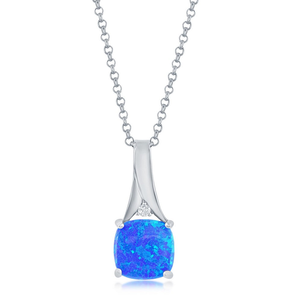 The Classic of New York Caribbean Opal Square Prong Set Necklace features a vibrant blue opal pendant in a rounded square shape, accented with a clear stone—ideal for fans of Caribbean opal necklaces. Includes chain.