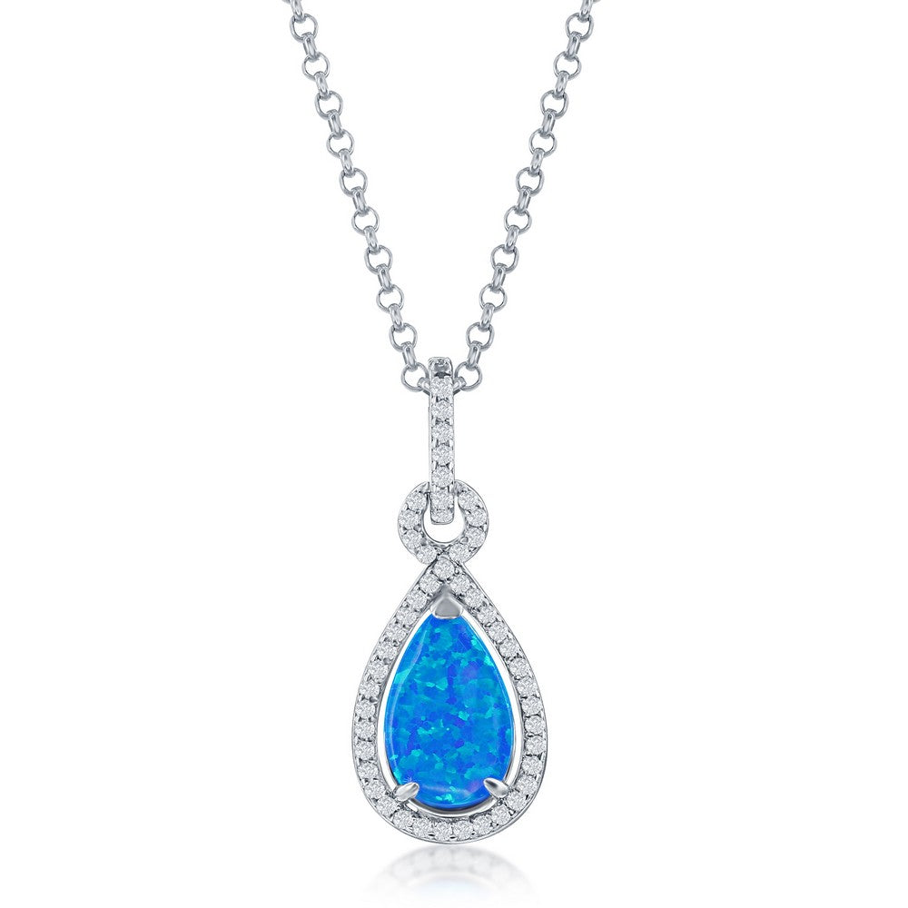 The Classic of New York Caribbean Opal 4 Prong Teardrop & CZ Border Necklace features a blue opal teardrop pendant with cubic zirconia accents on a delicate chain—a striking piece among Caribbean opal necklaces.